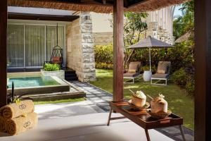 a living room with a table and a pool at Suites & Villas at Sofitel Bali in Nusa Dua