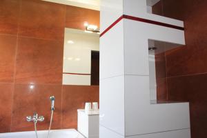 a bathroom with a tub and a shower with a mirror at Apartament Night Premium Krakow in Krakow