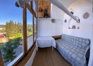 Habitación pequeña con sofá y ventana grande. en Apartament Viva Predeal, en Predeal