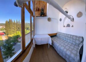 プレデアルにあるApartament Viva Predealのソファと大きな窓が備わる小さな客室です。