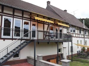 a building with a balcony and stairs on it at Ferienwohnungen Eder_Ufer in Hemfurth-Edersee