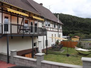 a house with a balcony and a yard with a boat at Ferienwohnungen Eder_Ufer in Hemfurth-Edersee