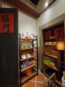 金城鎮にある歇會兒民宿典藏館の中国の品が入った棚付きの部屋