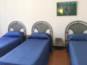 3 posti letto in una stanza con lenzuola blu di Trilo David a Costa Paradiso