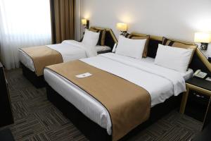 Tempat tidur dalam kamar di My House Hotel