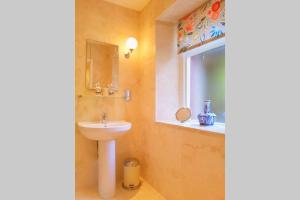 a bathroom with a sink, toilet and mirror at No 6 The Square Tearooms & Accommodation in Buxton