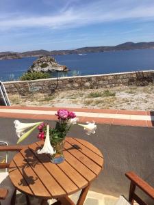 a table with a vase of flowers on a balcony at Loukakia apartments in Patmos +21 photos