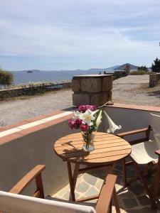 a table with a vase of flowers on a balcony at Loukakia apartments in Patmos