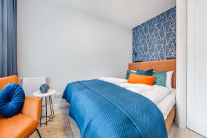 una camera con un letto blu e una sedia di Apartamenty Sun & Snow Residence II Jastrzębia Góra a Jastrzębia Góra