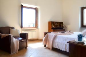 1 dormitorio con 1 cama, 1 silla y 1 ventana en Caratteristico appartamento nel cuore della Tuscia, en Vetralla