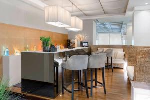 een keuken met een bar met krukken bij Hotel Lungomare in Riccione +73 foto's