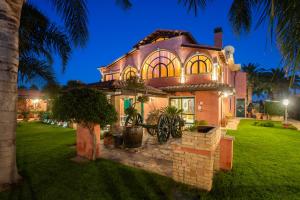 a house with a palm tree in the yard at Villa Flumini in Flumini di Quartu