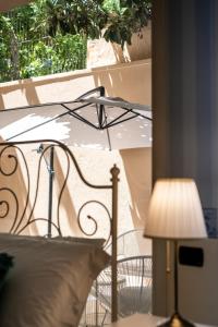 a bedroom with a bed with a lamp and a window at Palazzo Chiara in Cagliari