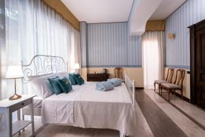 una camera da letto con un letto bianco con cuscini blu di Palazzo Chiara a Cagliari