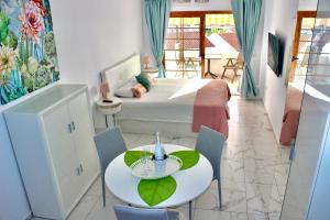 1 dormitorio con 1 cama, mesa y sillas en Garden City PREMIUM - Full seaview, en Playa Fañabe