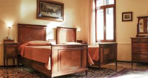 a bedroom with a wooden bed and two dressers at B&B Corte Campana in Venice