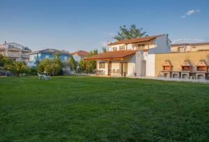 a house with a green lawn in front of it at Nicole Fresh Apartments in Keramoti