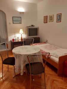 a room with a table and chairs and a bed at Tisno Sea View apartment in Tisno