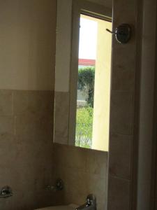 specchio in bagno con lavandino e finestra di Casa Vacanze Barone di Civico 24 a Scicli
