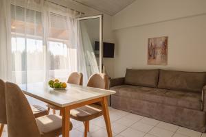 Nicole Fresh Apartments في كيراموتي: غرفة معيشة مع طاولة وأريكة