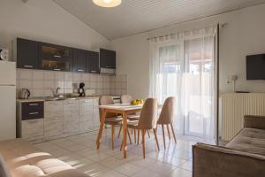 Nicole Fresh Apartments في كيراموتي: مطبخ وغرفة طعام مع طاولة وكراسي