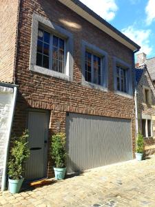 een stenen huis met twee garagedeuren erop bij Studio Het Begijntje Tongeren in Tongeren