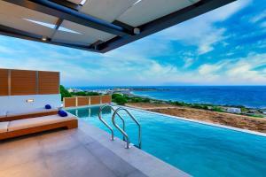 a swimming pool with a view of the ocean at Amphitheatre Suites in Palaiochóra