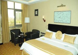 Continent Al Waha Hotel Riyad في الرياض: غرفة فندقية بسرير وكراسي كبيرة