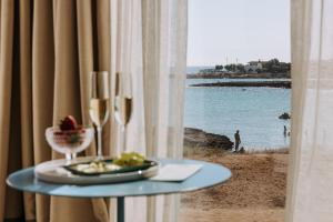 a table with a plate of food and a view of the beach at Miramare Blue Stay in Torre Santa Sabina