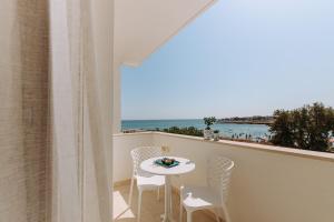 a balcony with a table and chairs and a view of the ocean at Miramare Blue Stay in Torre Santa Sabina