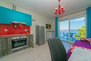 a kitchen with blue cabinets and a view of a balcony at Apartments La Flor in Brela