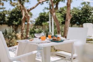 a white table and chairs with food on it at Miramare Blue Stay in Torre Santa Sabina