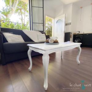 a white coffee table in a living room with a couch at Le Chat Vert - Gîte de Charme in Saint-André +59 photos