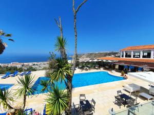 
a beach with palm trees and palm trees at Miramar Hotel Spa & Apartments in Nazaré
