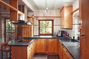 cocina con armarios de madera y encimera negra en Apartment Wachinghof, en Reith bei Kitzbühel