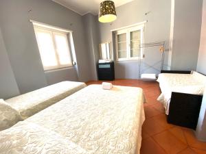1 Schlafzimmer mit 2 Betten und 2 Fenstern in der Unterkunft Apartamentos Lux Dinastia in Lissabon
