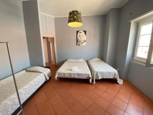 Cette chambre comprend deux lits et une lampe. dans l'établissement Apartamentos Lux Dinastia, à Lisbonne