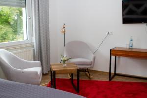 Schlafzimmer mit einem Bett, einem Schreibtisch und einem Stuhl in der Unterkunft Stadthotel Marburg in Marburg an der Lahn