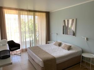 a bedroom with a large bed and a chair at Ambassador Salgados Beach Suites in Albufeira +18 photos