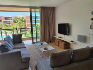a living room with a couch and a flat screen tv at Ambassador Salgados Beach Suites in Albufeira