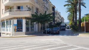 a street with cars parked in front of a building at Moraira Beach in Moraira