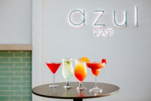 four cocktails on a table in front of a bar at Cosmo Napa Boutique Hotel in Ayia Napa