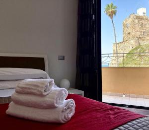 テルモリにあるIamartino Quality Roomsの赤い毛布の上にタオルを敷いたベッドが備わる部屋