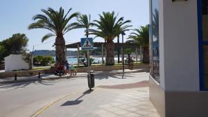a pedestrian crossing sign on a street with palm trees at Moraira Beach in Moraira