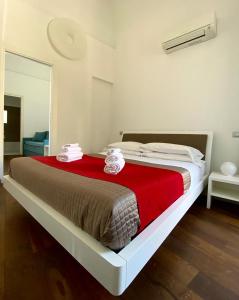 um quarto com uma cama grande e um cobertor vermelho em Iamartino Quality Rooms em Termoli