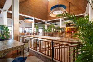 a lobby with tables and potted plants in a building at Grande Real Santa Eulalia Resort & Hotel Spa in Albufeira