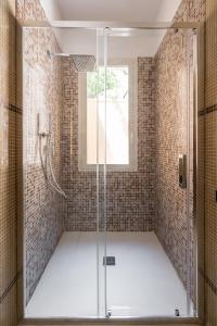 y baño con ducha y puerta de cristal. en Palazzo Chiara, en Cagliari