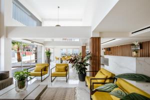 a living room with yellow chairs and a table at Cosmo Napa Boutique Hotel in Ayia Napa