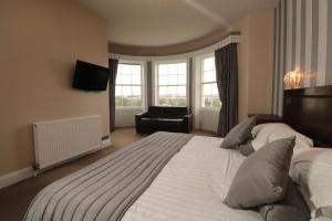 una habitación de hotel con una cama grande y una silla en The Esplanade Hotel, en Scarborough