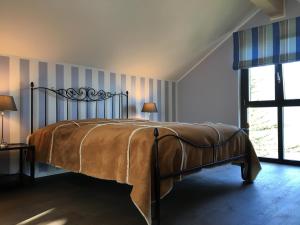 a bed in a bedroom with a striped wall at Rustico RESA: Brione sopra Minusio in Brione sopra Minusio